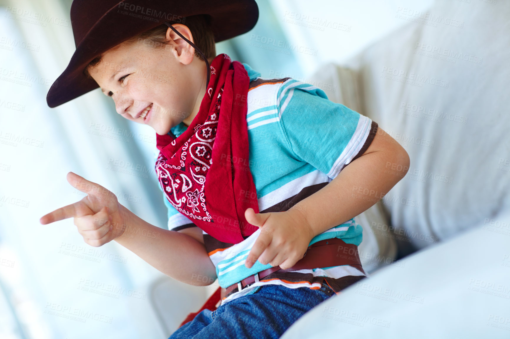 Buy stock photo Happy kid, cowboy and play game with gun gesture for fantasy or creative cosplay in home lounge. Boy child, western costume and pistol fingers on sofa for shooting, target or dress up for halloween