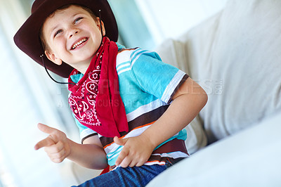 Buy stock photo Happy child, cowboy and play game with gun gesture for fantasy or creative cosplay in home lounge. Kid boy, western costume and pistol fingers on sofa for shooting target and dress up for halloween