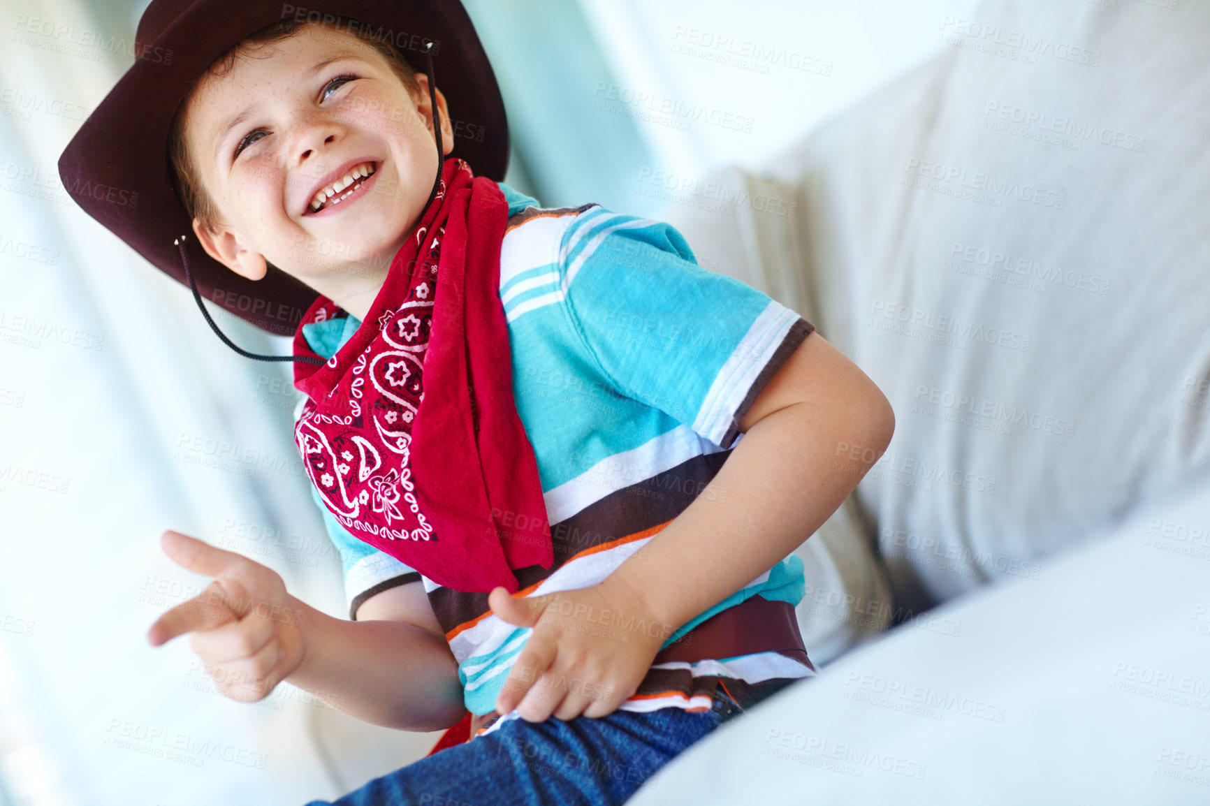 Buy stock photo Happy child, cowboy and play game with gun gesture for fantasy or creative cosplay in home lounge. Kid boy, western costume and pistol fingers on sofa for shooting target and dress up for halloween