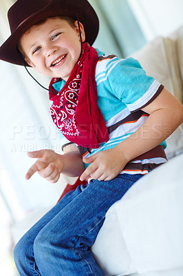 Buy stock photo Child, boy and portrait with cowboy costume on sofa for fantasy play, shooting game or pointing pretend gun. Person, kid or hand gesture in home for halloween, dress up or protection with imagination