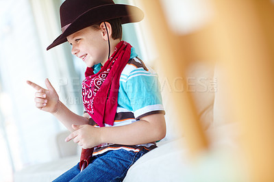 Buy stock photo Kid, boy and smile with cowboy costume on sofa for fantasy play, shooting game or pointing pretend gun. Person, happy and hand gesture in home for halloween, dress up and protection with imagination