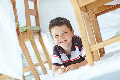 Buy stock photo Boy, happy child and fort in home portrait, playing hide and seek on floor of living room. Male person, kid imagine and tent for games on carpet in France, healthy growth and development in lounge