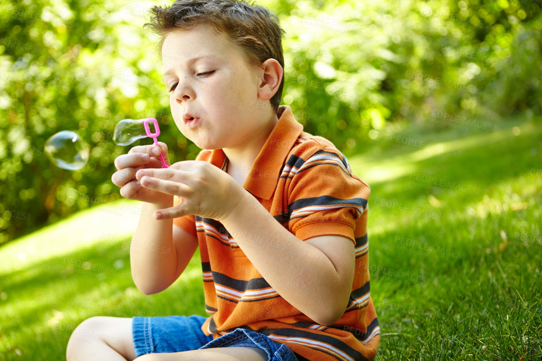 Buy stock photo Outdoor, child and playing with bubbles for blowing, having fun and childhood development with games. Garden, young boy and growth with toy wand for entertainment, freedom and peace with soap in park