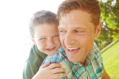 Buy stock photo A happy little boy being carried by his father on a sunny day