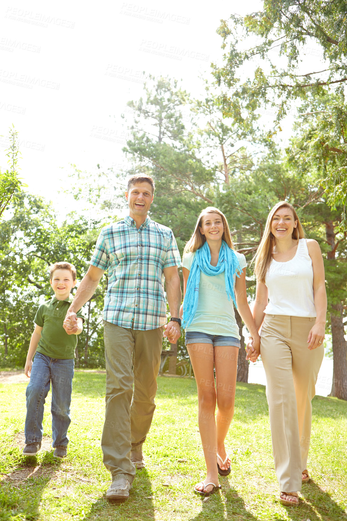 Buy stock photo Happy family, portrait and holding hands in park for love, trust and excited for adventure in Australia. Parents, children and gesture in nature for guidance, support and safety on summer vacation