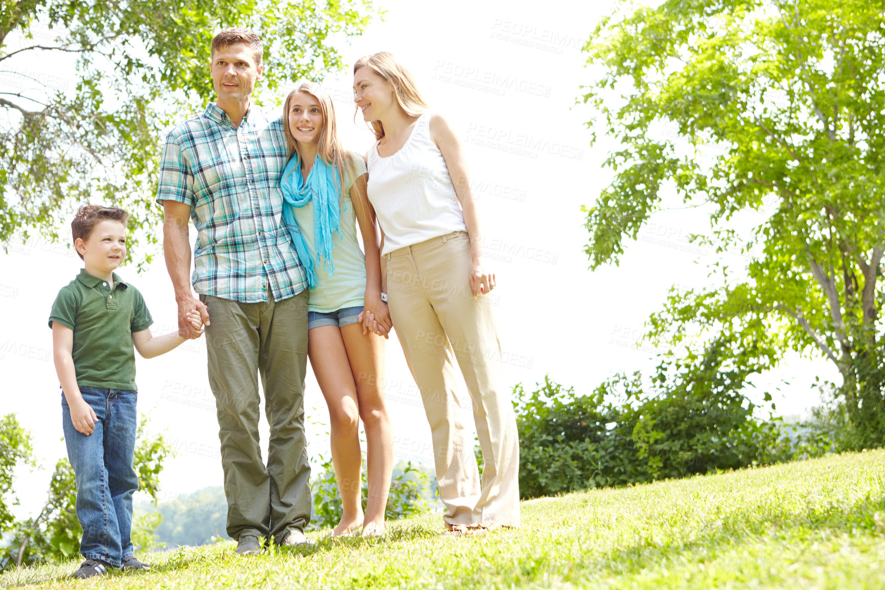 Buy stock photo Holding hands, happy family and parents with kids outdoor for holiday, vacation and people bonding. Smile, mother and father with children at park for love, support and care with siblings together