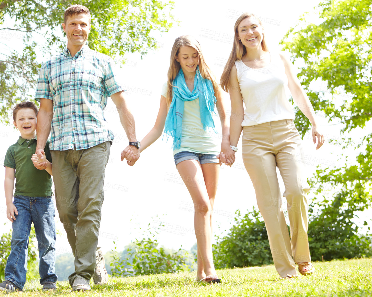 Buy stock photo Family, smile and holding hands in nature for love, trust and excited for adventure in Australia. Parents, children and gesture in park for guidance, support and safety on holiday or summer vacation