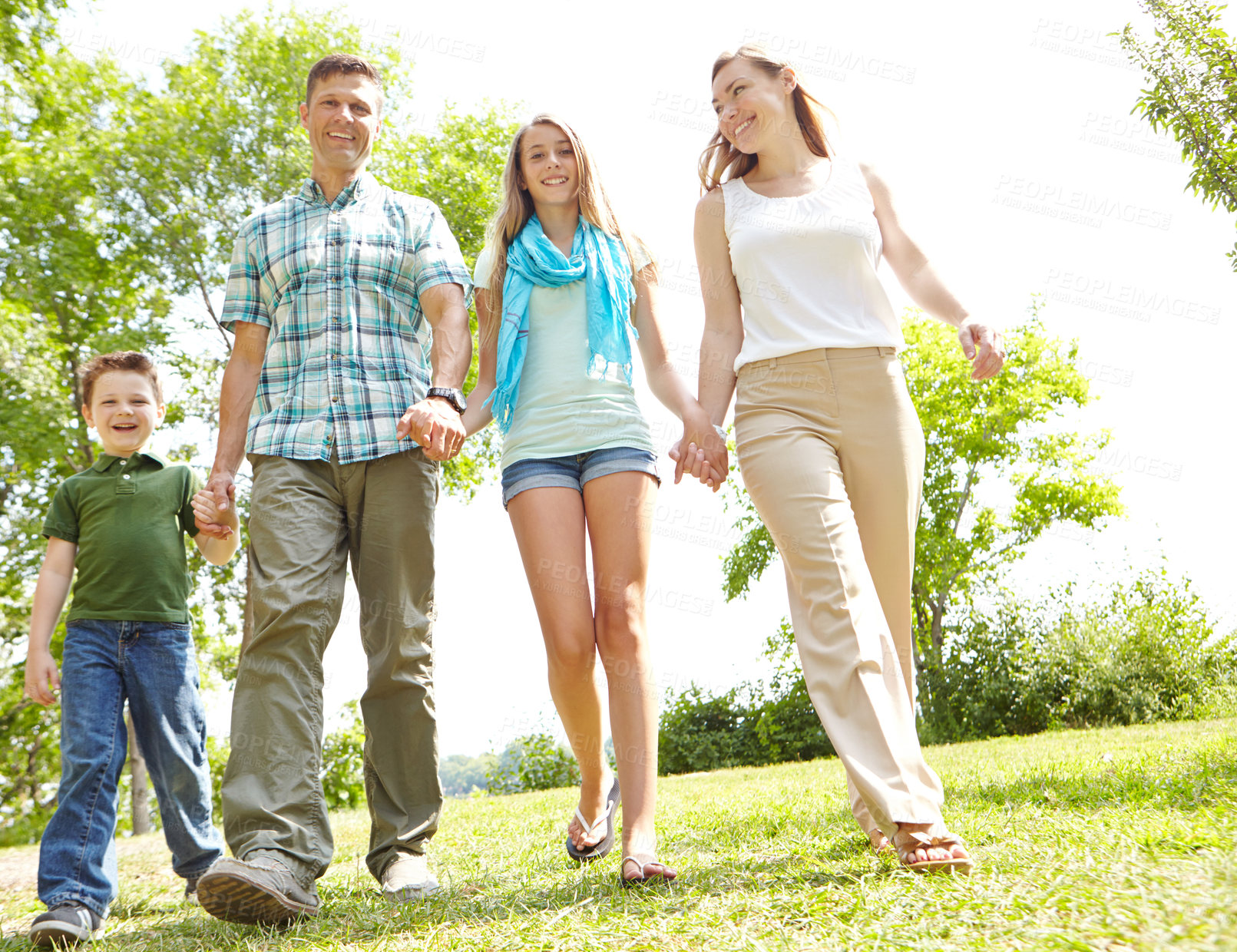 Buy stock photo Family, happy and holding hands in nature for trust, love and excited for adventure in Australia. Parents, children and gesture in park for guidance, support and safety on holiday or summer vacation