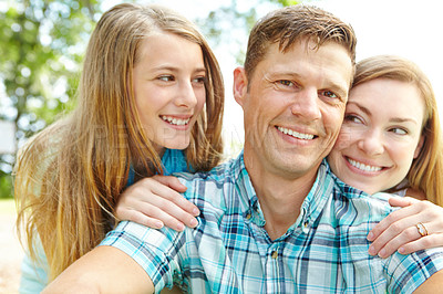 Buy stock photo A happy young family relaxing together on a sunny day