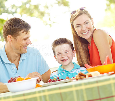 Buy stock photo Portrait, family and bonding with food, picnic and parents with child, nutrition and healthy in nature. Happy, woman and man with kid, vegan and fruit in weekend, fun and break in park and together