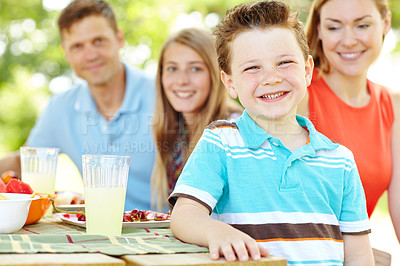 Buy stock photo A happy young family relaxing in the park and enjoying a healthy picnic