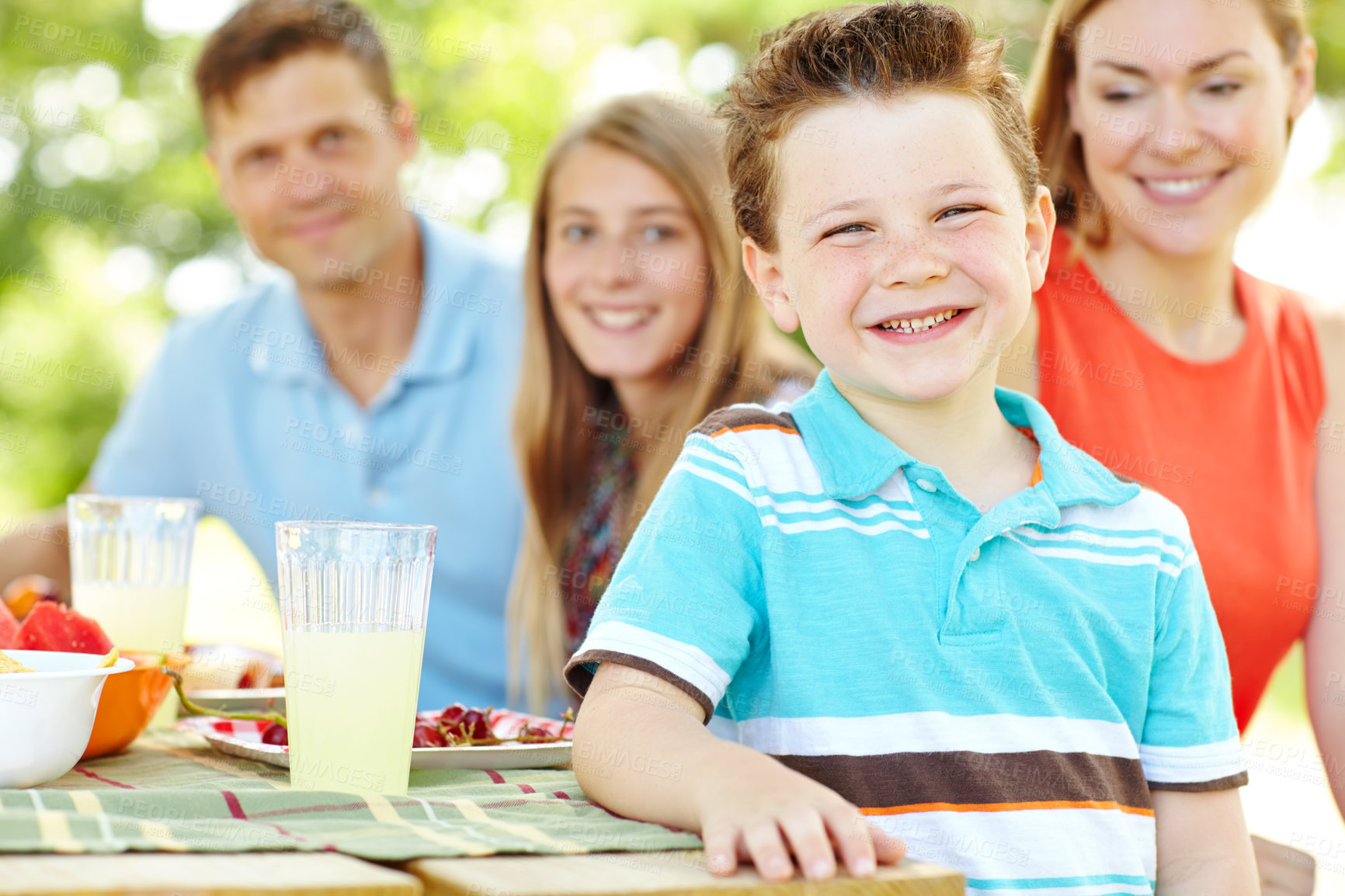 Buy stock photo Portrait, happy family and kid at picnic with food for party and eating for thanksgiving. Face, lunch and people together outdoor with mother, father and children for celebration on summer holiday