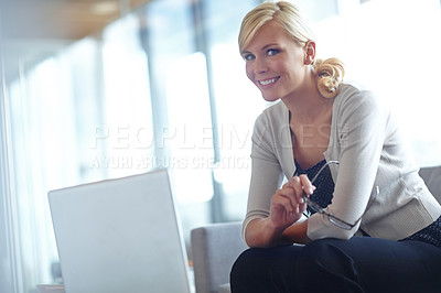 Buy stock photo Portrait of a smiling business woman sitting behind her laptop and holding her eye glasses with copyspace