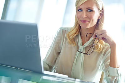 Buy stock photo Portrait of a beautiful corporate woman sitting at her desk with her laptop in front of her