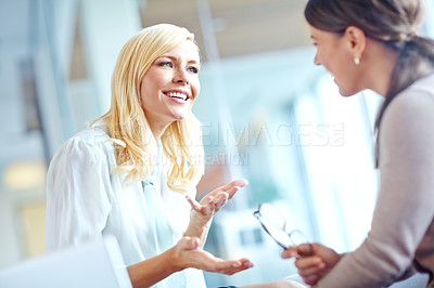 Buy stock photo Two corporate women sharing a joke at the office