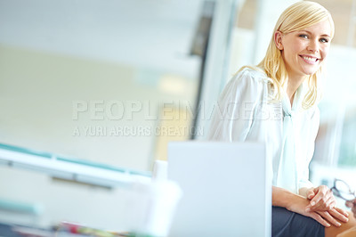 Buy stock photo Portrait of a beautiful corporate woman sitting on a desk with a laptop next to her - Copyspace