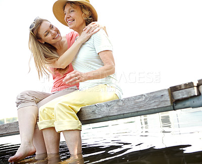 Buy stock photo Lake, senior mother and daughter with smile for love, support and relax in Germany. People, parent and happiness outdoor on water dam sky for holiday, break and nature for bonding and respect