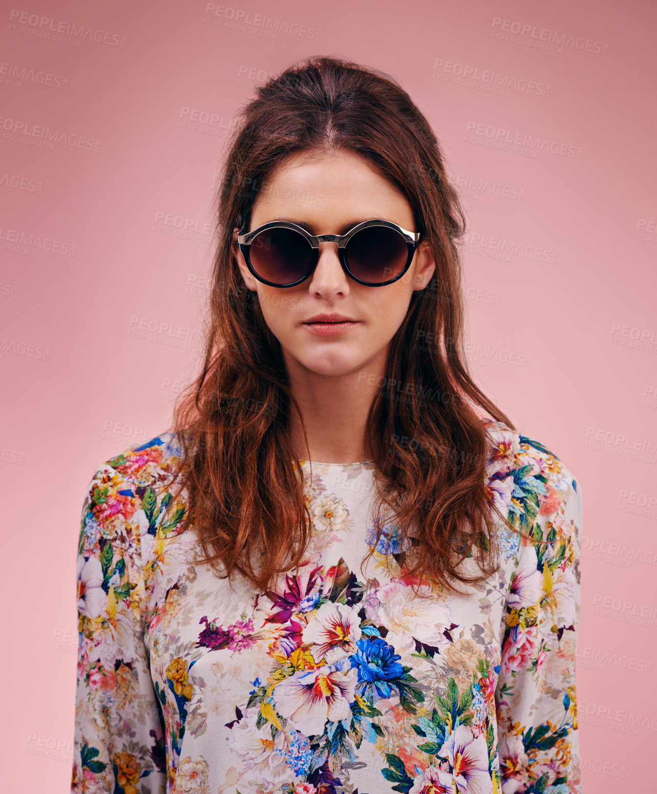 Buy stock photo Portrait of an attractive young woman wearing designer shades against a pink background