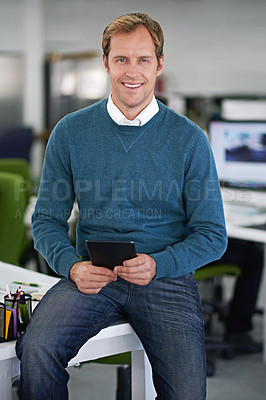 Buy stock photo Cropped shot of a handsome businessman sitting on his desk with a few colleagues in the background