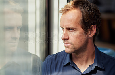 Buy stock photo Shot of a man looking thoughtfully through a window
