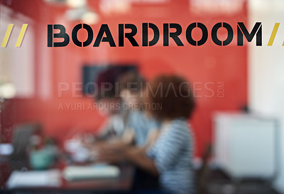 Buy stock photo Closeup shot of a sign on a boardroom window with businesspeople blurred in the background