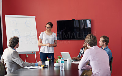 Buy stock photo Shot of a woman giving a presentation to a group of colleagues in a boardroom