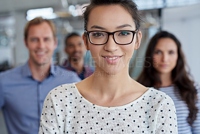 Buy stock photo Cropped portrait of a young woman with her coworkers in the background