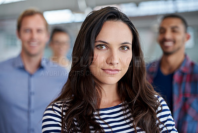 Buy stock photo Portrait of a serious young woman with colleagues in the background