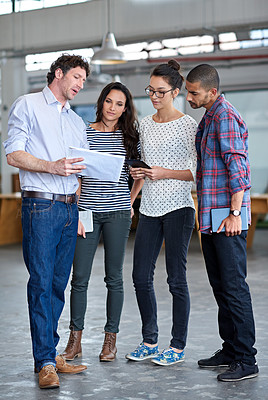 Buy stock photo Group of staff discussing something while standing in their office space