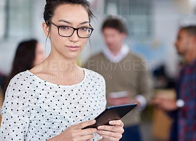 Buy stock photo Cropped portrait of a serious young woman holding a digital tablet in an office space