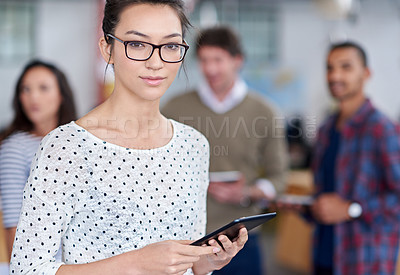 Buy stock photo Cropped image of a young woman holding a digital tablet with colleagues in the background