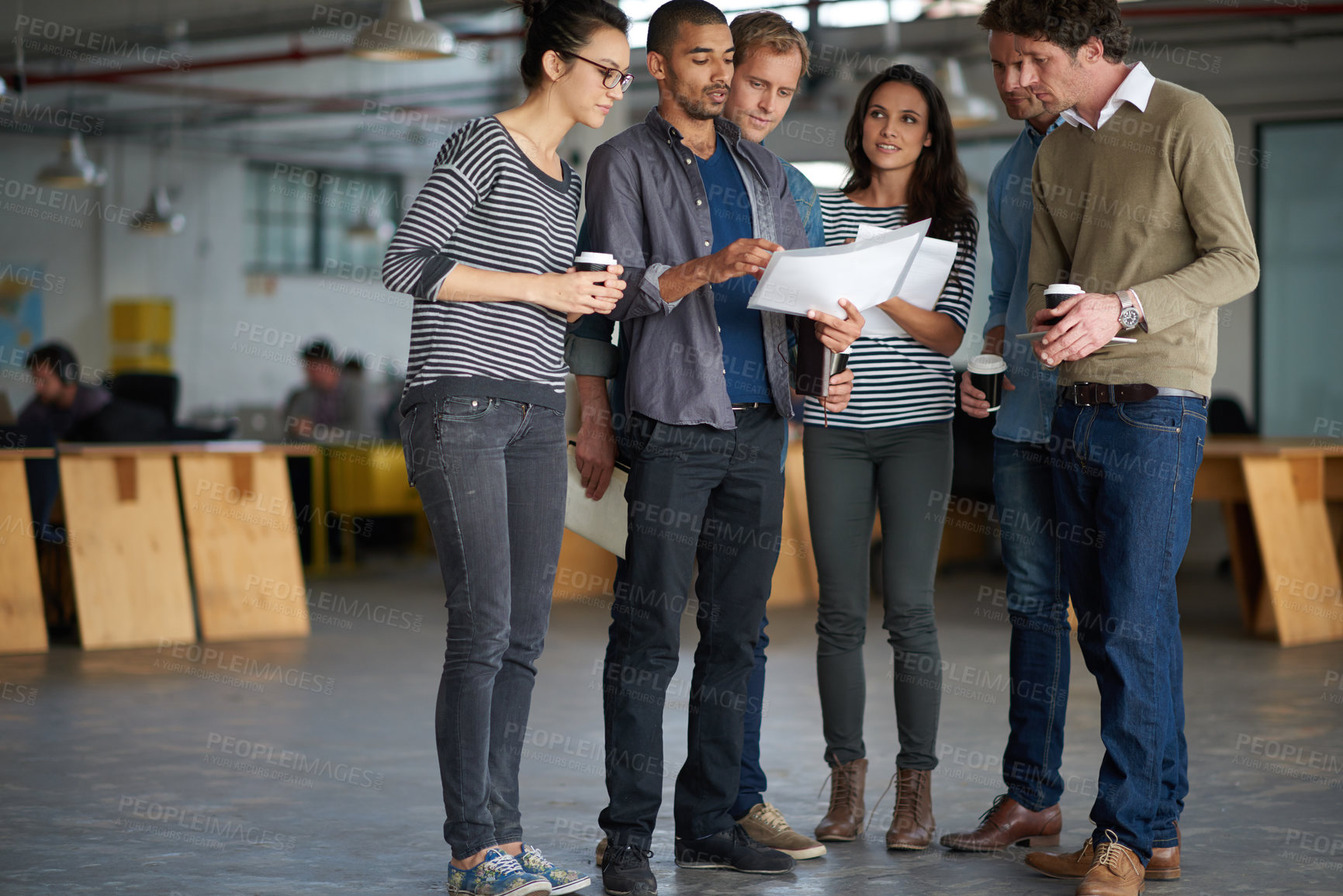 Buy stock photo Full length shot of a group of staff standing around a young man with papers