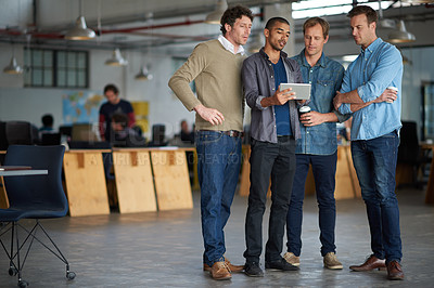 Buy stock photo Full length shot of four male colleagues discussing an issue while sharing a view of a digital tablet