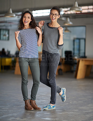 Buy stock photo Two female colleagues posing together in their creative work space