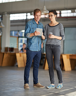 Buy stock photo A man showing something on his digital tablet to a colleague