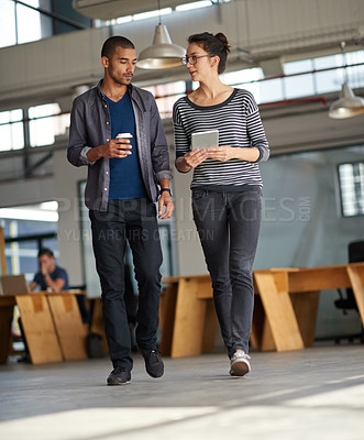 Buy stock photo Creative colleague chatting while walking across their open plan office