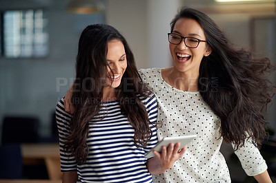 Buy stock photo Vivacious young woman surprising her friend with a side hug in their office space