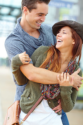 Buy stock photo Funny, love and couple hug in city for support, care or connection for healthy relationship on holiday. Man, woman laugh and embrace outdoor for romance, joke or talking to partner on date together