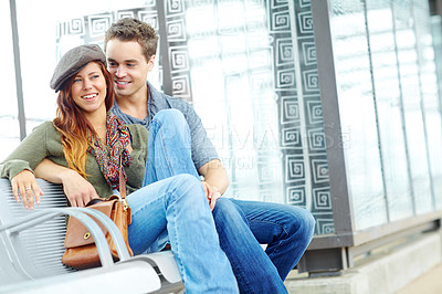 Buy stock photo Portrait of an attractive couple sitting at the train station with copyspace