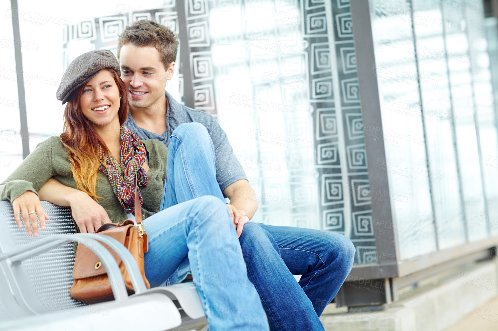 Buy stock photo Portrait of an attractive couple sitting at the train station with copyspace