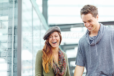 Buy stock photo A laughing couple walking in a train station with copyspace