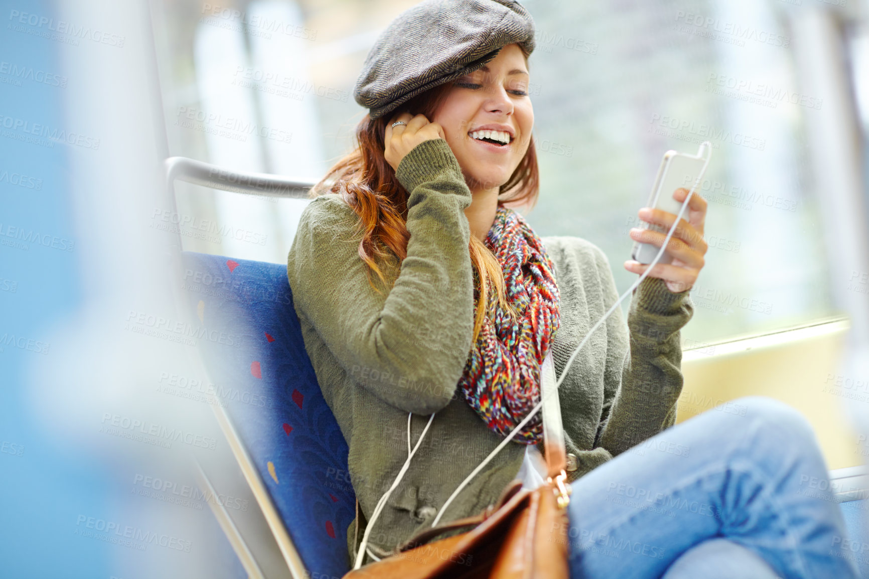 Buy stock photo Pretty girl on a train listening to her music on her phone with copyspace
