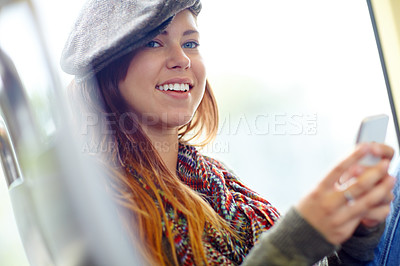 Buy stock photo close up of a smiling girl on the train holding her cellphone