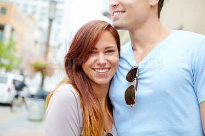 Buy stock photo Portrait of a beautiful girl being embraced by her boyfriend on a city street