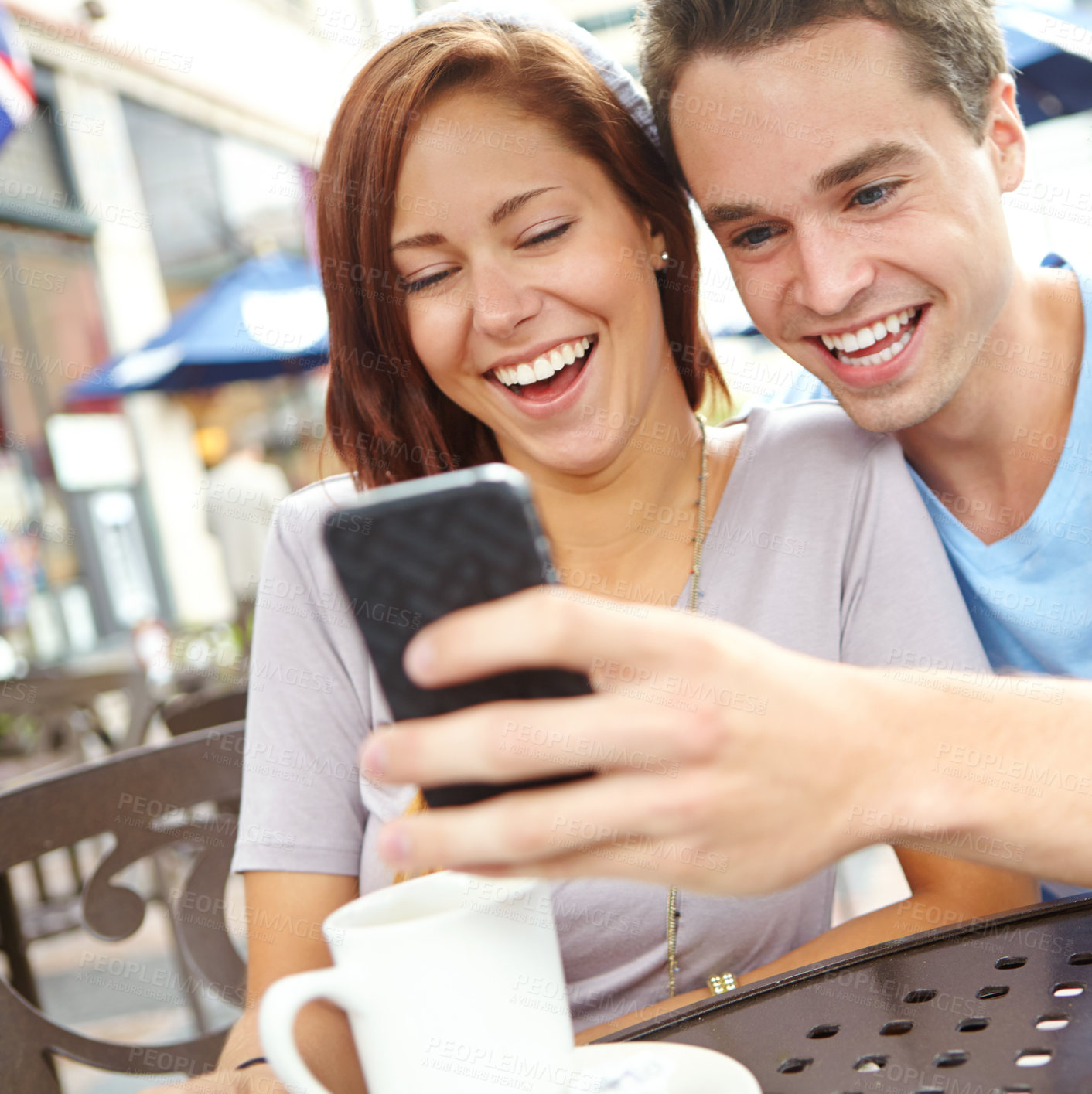 Buy stock photo Outside, couple and happy at cafe on smartphone with online memes, funny videos and entertainment. People, relationship and smile or laughing on internet or social media for fun, bonding and care