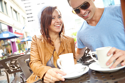 Buy stock photo A happy couple having coffee at an outside cafe with copyspace