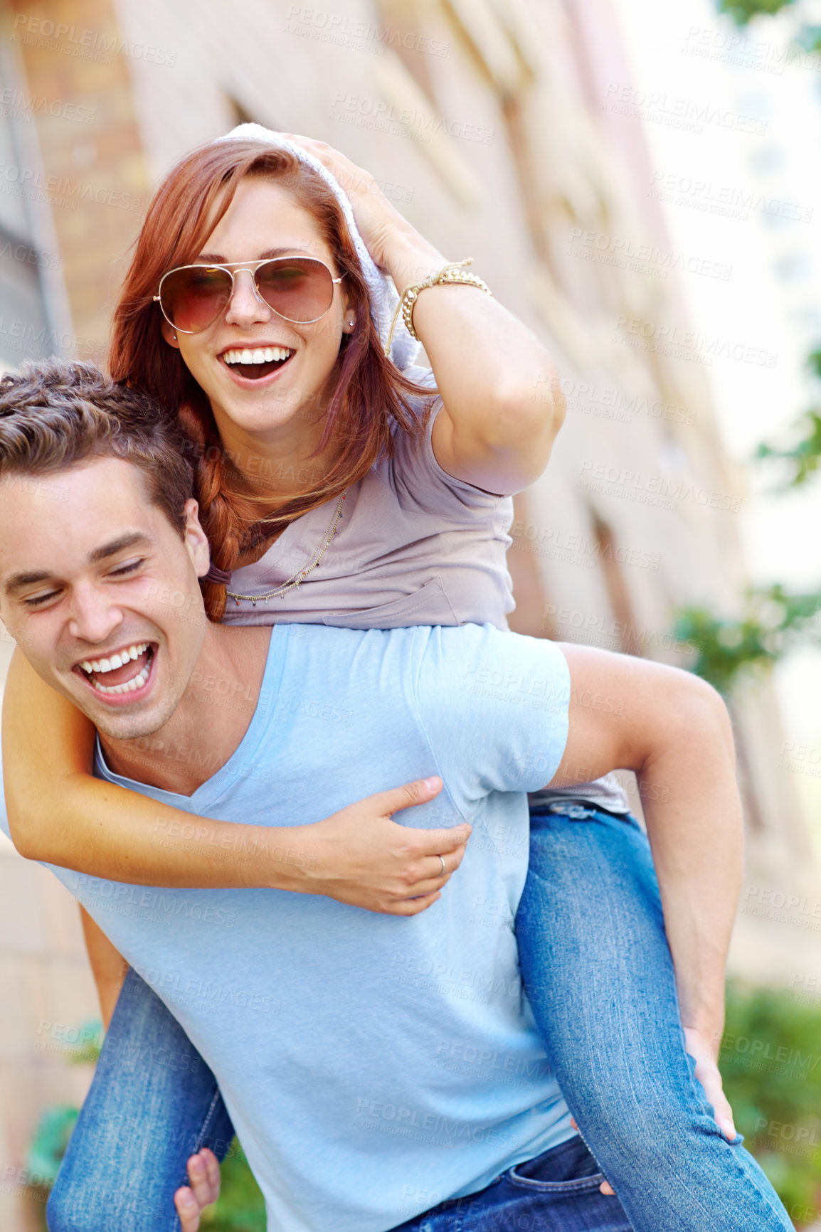 Buy stock photo A happy girlfriend getting a piggyback from her boyfriend