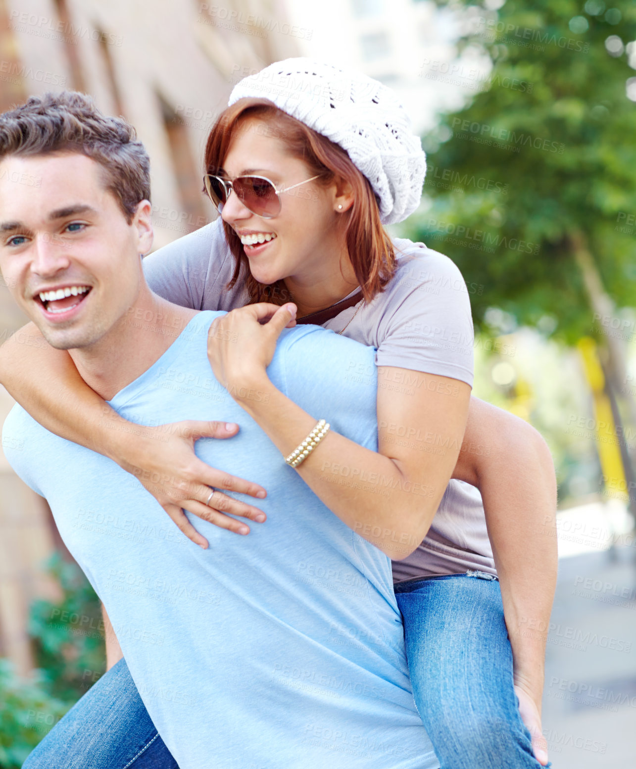 Buy stock photo A happy girlfriend getting a piggyback from her boyfriend