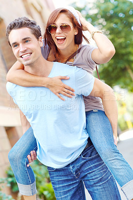 Buy stock photo A happy girlfriend getting a piggyback from her boyfriend with copyspace