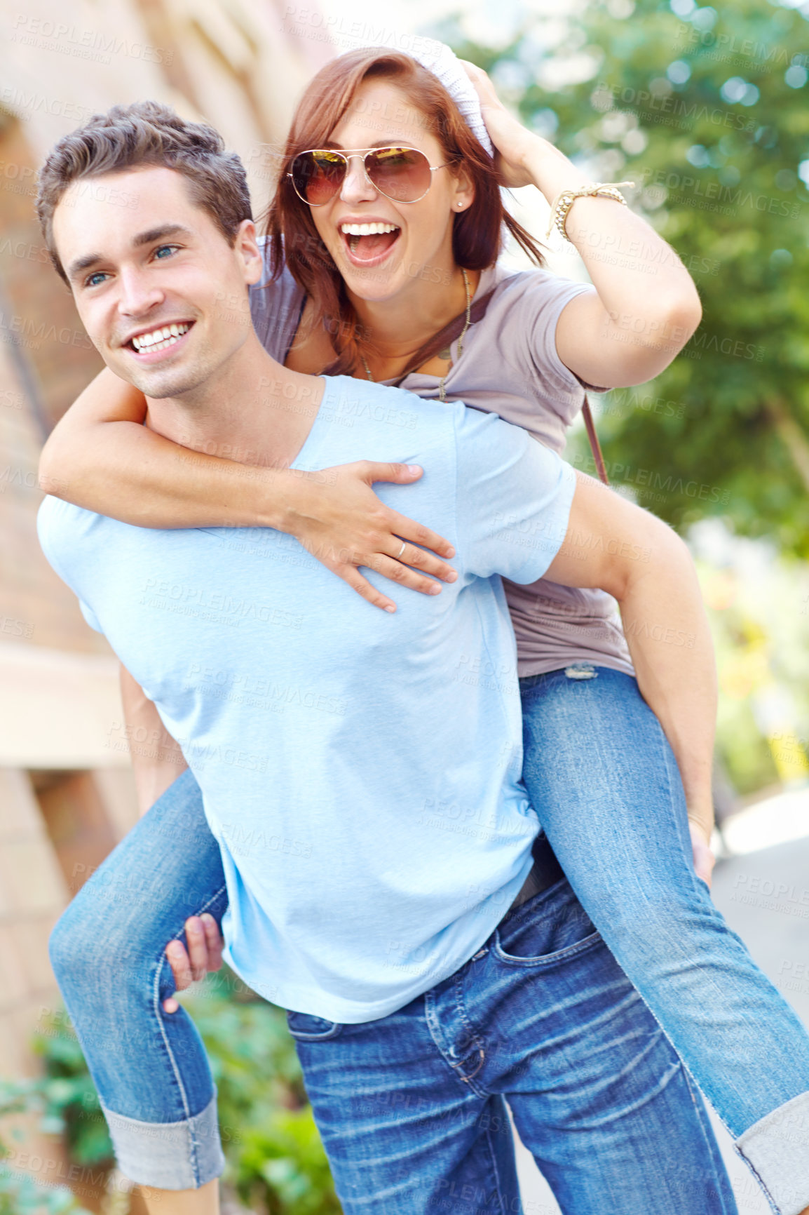 Buy stock photo A happy girlfriend getting a piggyback from her boyfriend with copyspace